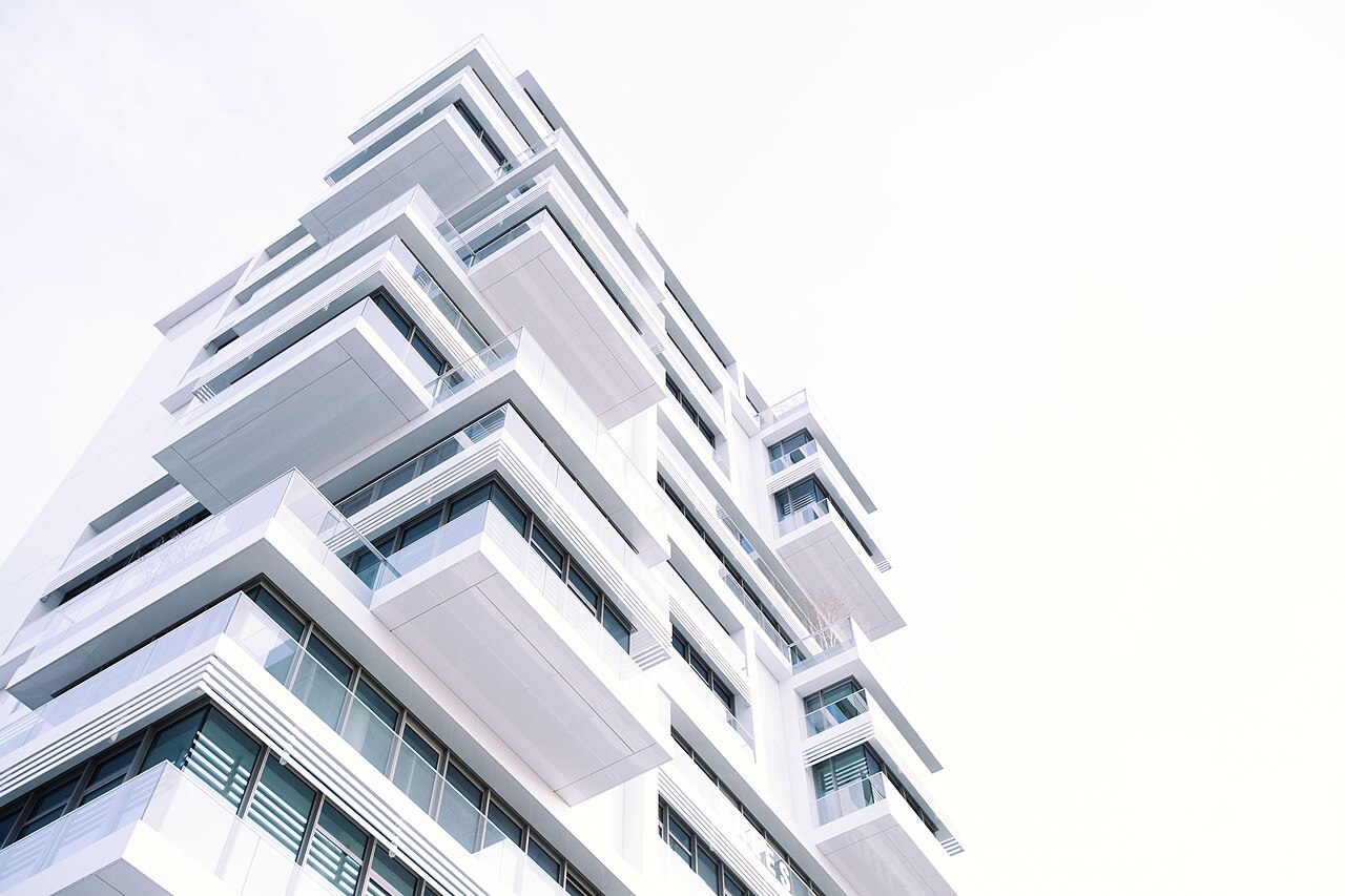 Modern white multi-story apartment building viewed from below